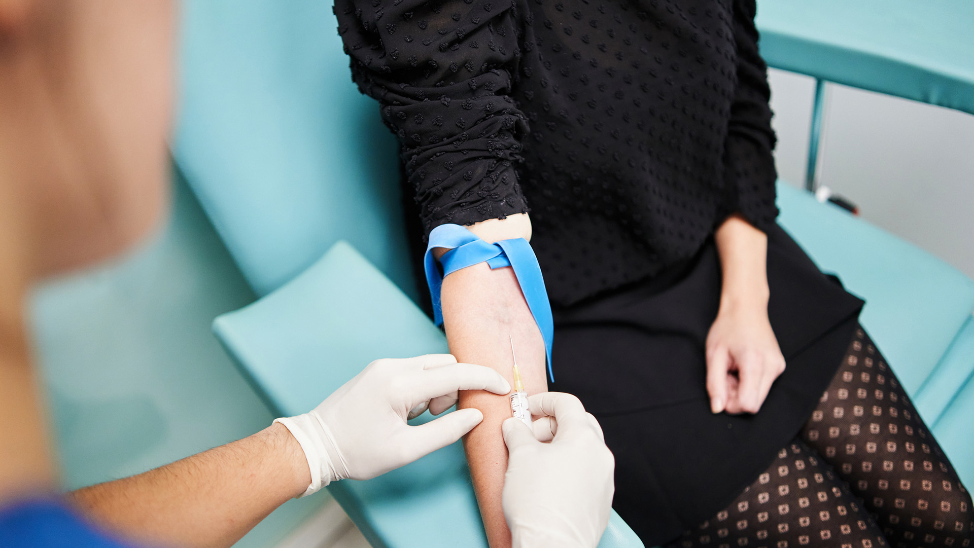 A view of a woman's arm as a nurse puts a needle into her vein