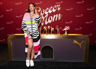 Rihanna wearing a polo Christopher John Rogers dress with sneakers in front of a soccer mom display