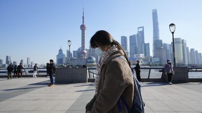 A woman observes a moment of silence in Shanghai during the memorial service
