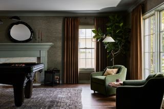 living room with tan curtains and green accent chairs
