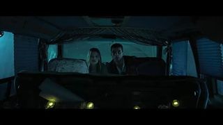 a dark still of a man and women sitting in a dark vehicle in the movie heart eyes