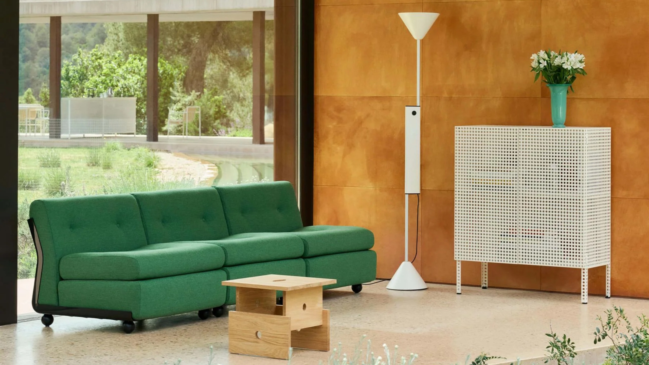 HAY Perforated Floor Cabinet in a modern living room with a green sofa, sculptural floor lamp and low wooden table.