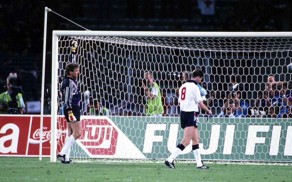 West Germany goalkeeper Bodo Illgner raises his first in celebration, while England's Chris Waddle walks away dejected after missing the decisive penalty during the shootout in the 1990 World Cup semi-final