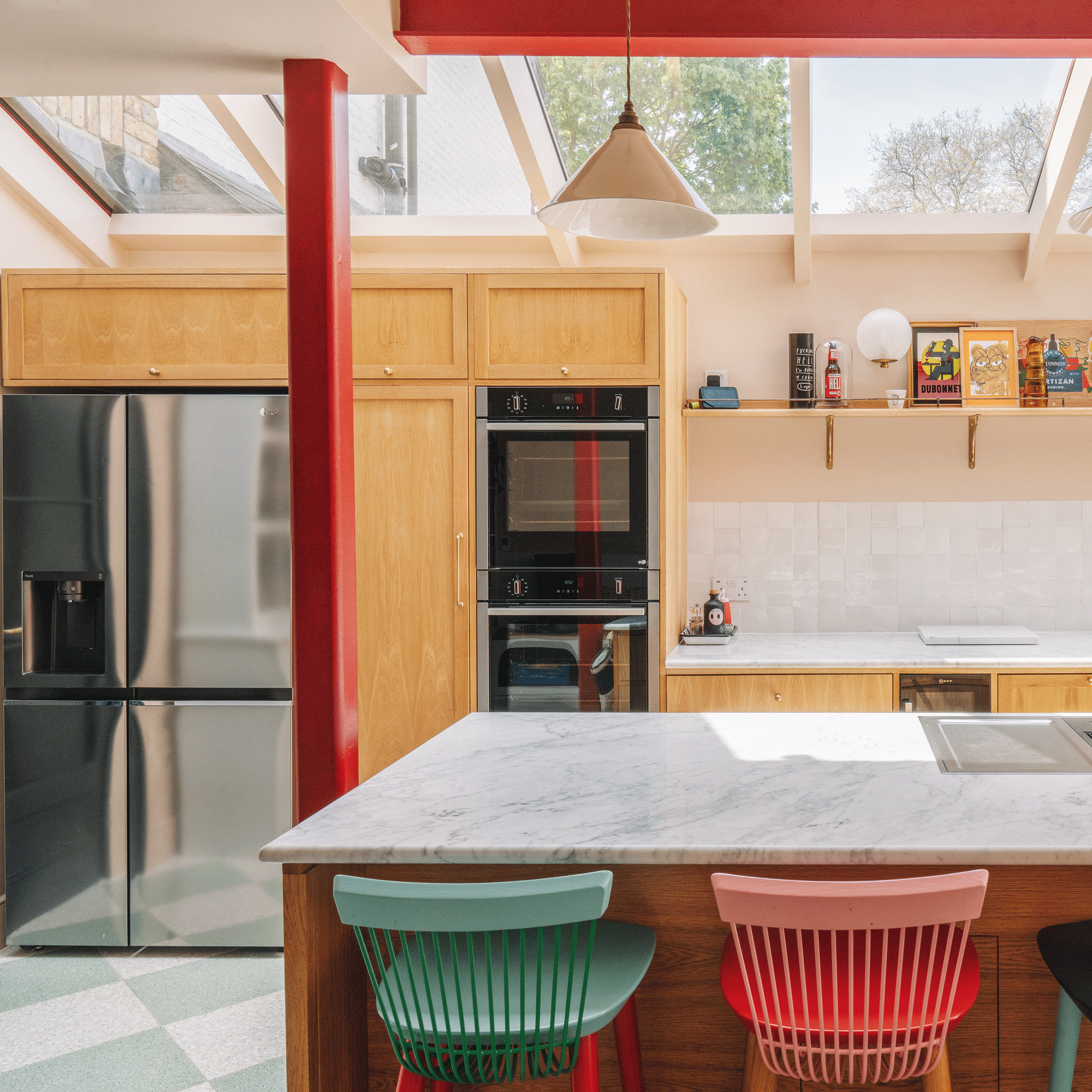 a kitchen with a large skylight wooden cabinets and colourful bar stools