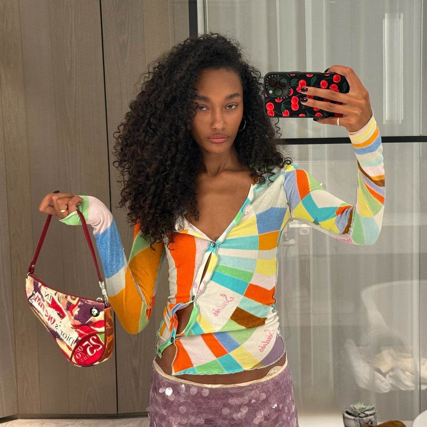 An image of a woman taking a mirror selfie with voluminous, textured hair.