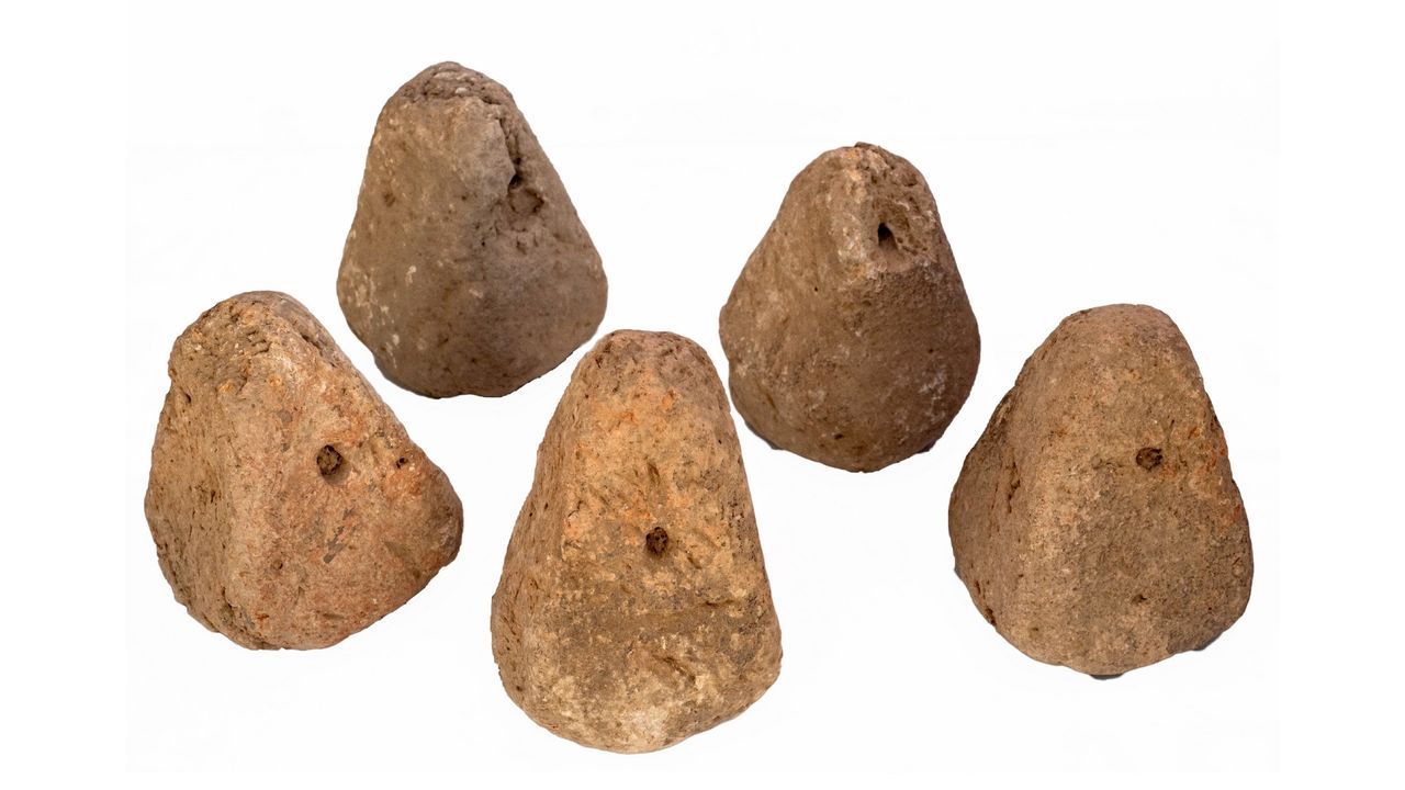This image shows five weights for weaving looms which were unearthed from the ruins of the farmstead in northern Israel. They all all pyramid-shaped but with soft edges/points.