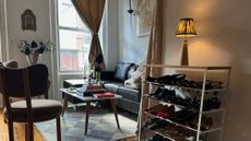 Pooky cordless table lamp with an ikat shade resting atop of a shoe rack, overlooking an NYC living room
