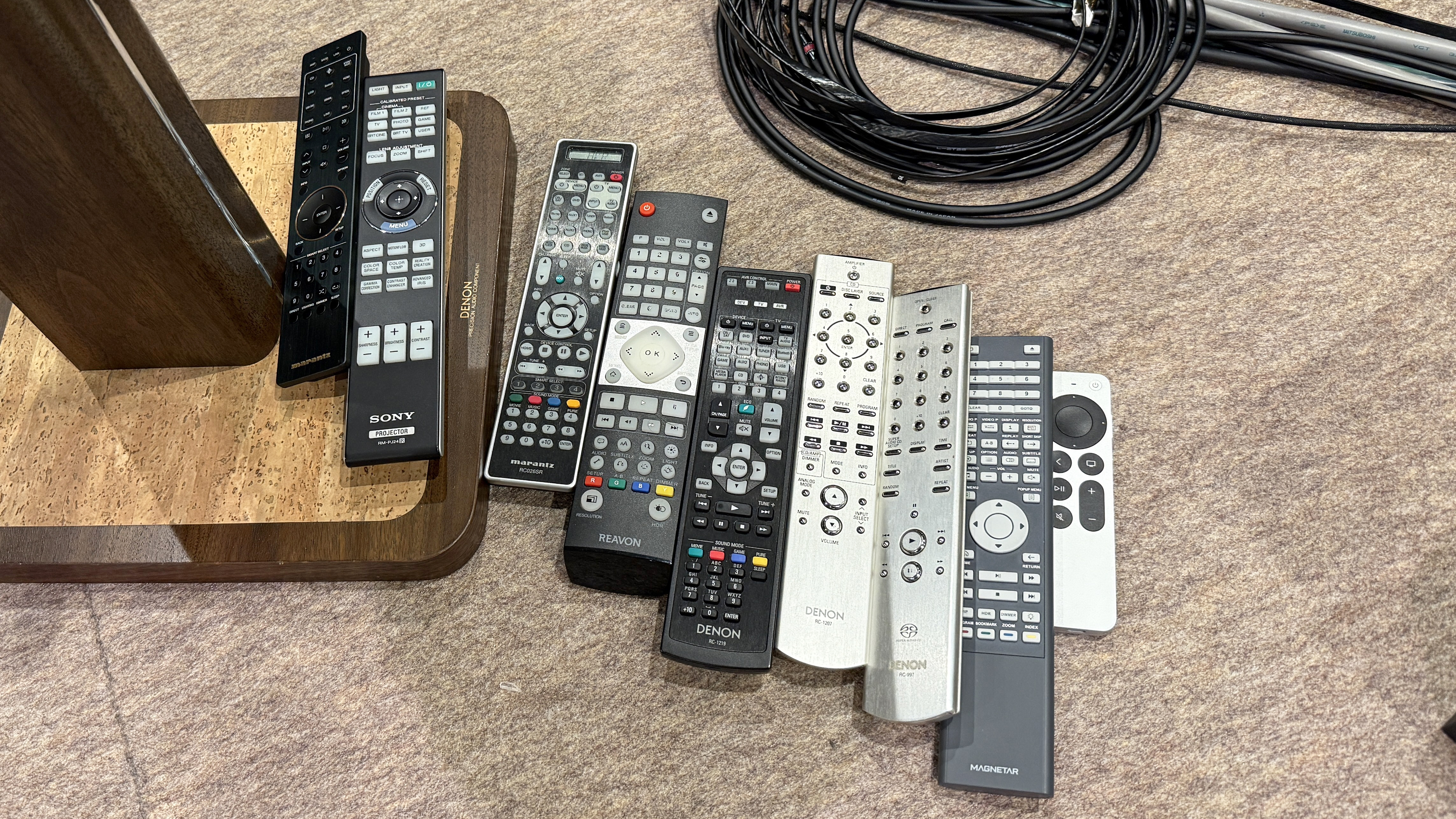 The interior of a home theater listening room with a load of remote controls on the floor