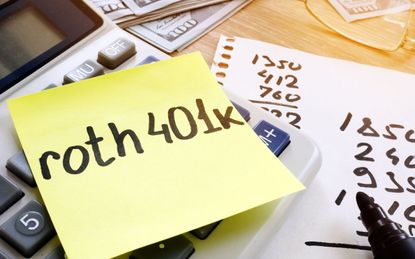 A sticky note with Roth 401(k) written on it on top of a calculator