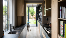 sustainable home with small galley kitchen with black countertops and parquetry floors