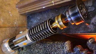 Star Wars Obi-Wan Kenobi Legacy Lightsaber hilt against a metal grate