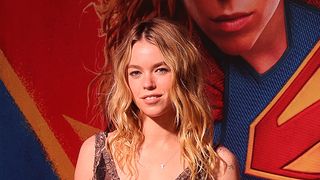 Milly Alcock at Brazil red carpet for Supergirl. Her face is on a poster in the background.