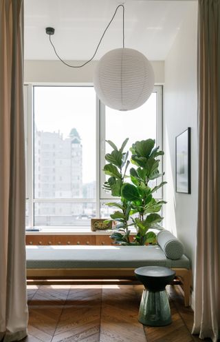 Green daybed with a hanging pendant light above