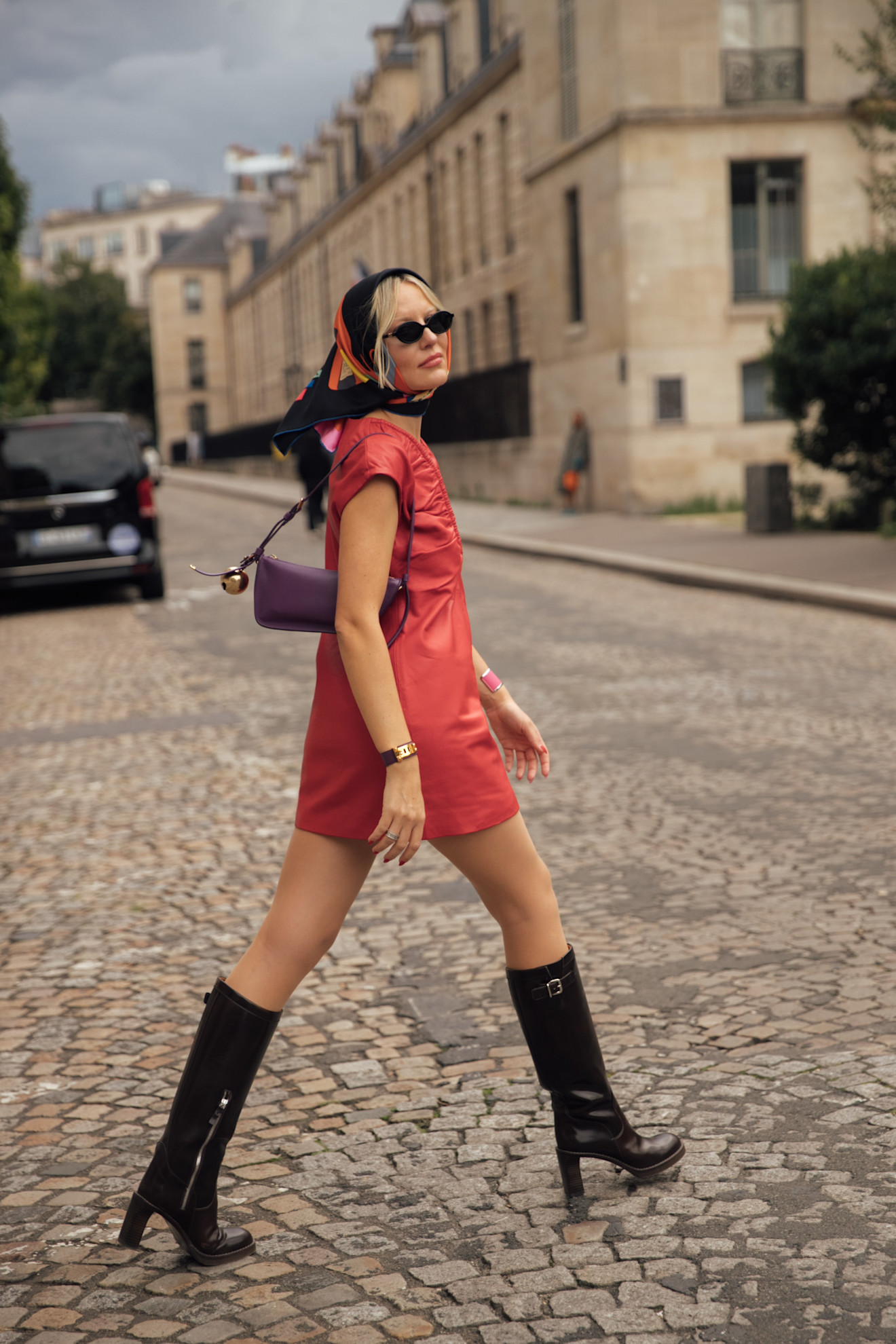 a woman wearing a silk scarf, red dress, black boots