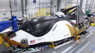 a white and black robotic space plane inside a hangar