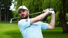 Barry Plummer holds a post-shot pose wearing The Big Golf Race polo and cap