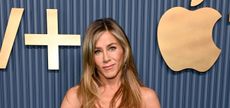 Jennifer Aniston in front of a blue ribbed board