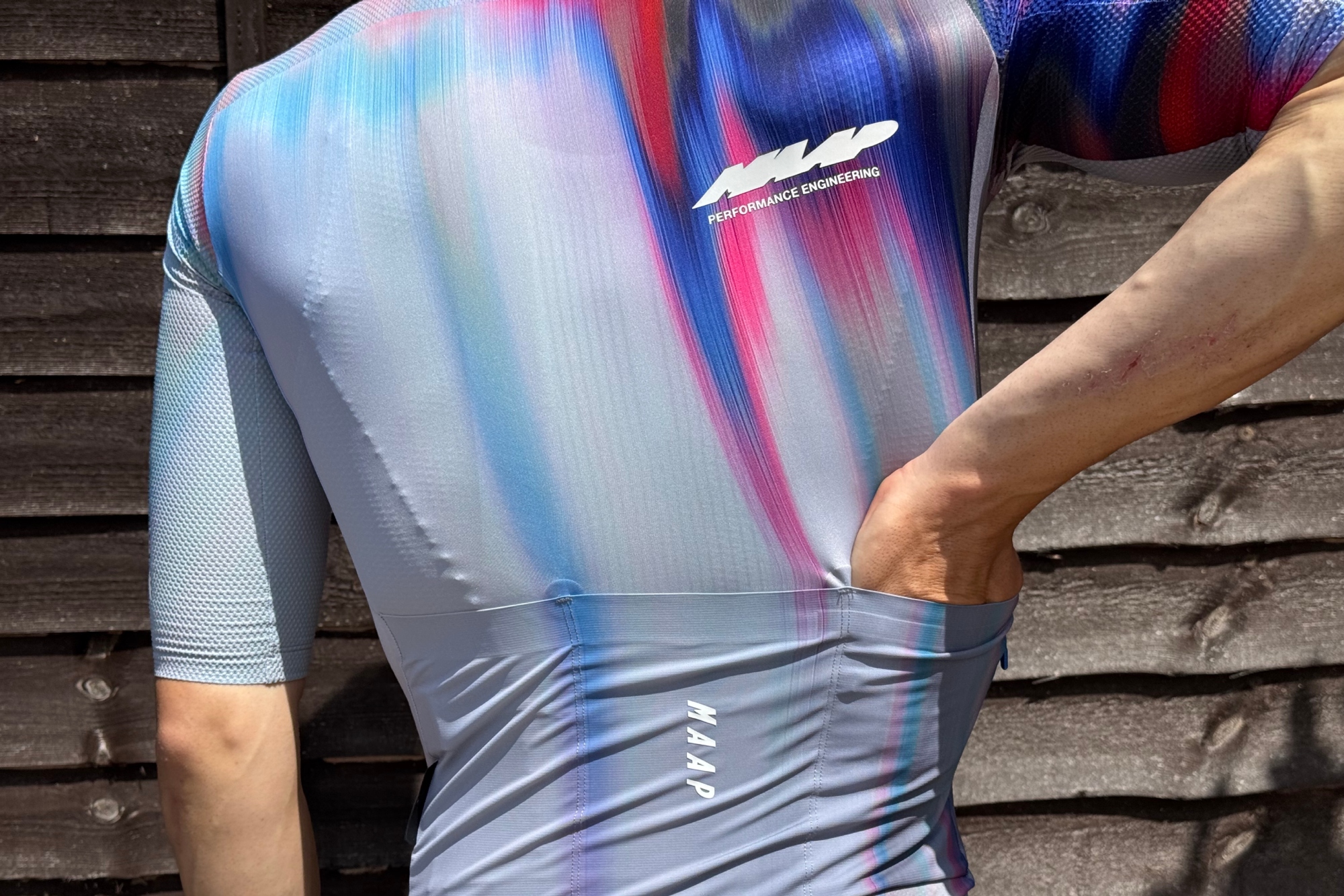 Andy Turner putting his hand in the rear pocket of the MAAP Pro Race jersey
