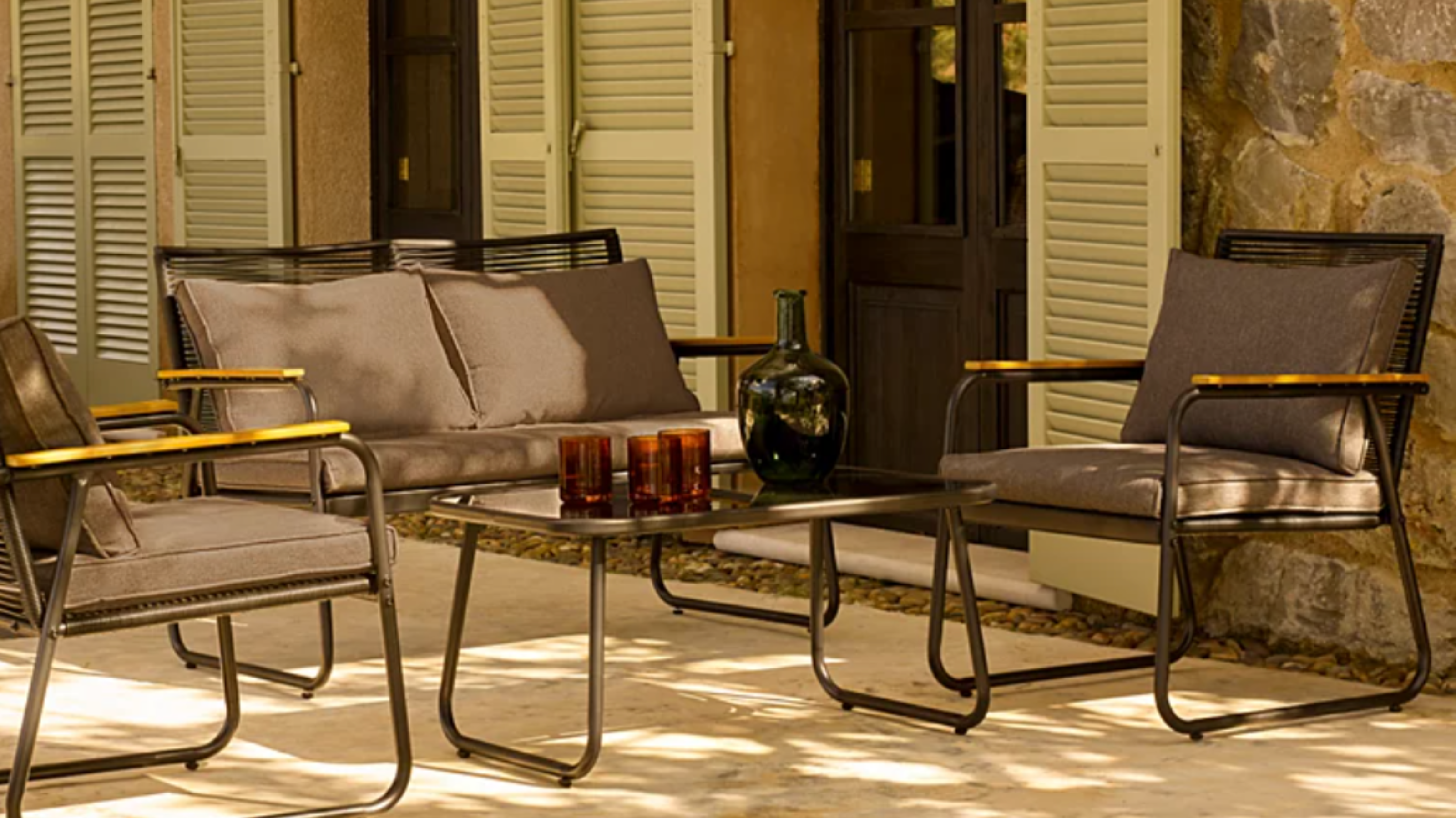 George Home Lisbon dining se on a patio in front of green french doors.