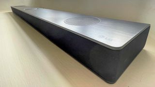 LG S95QR main soundbar on a white surface in reviewer's home