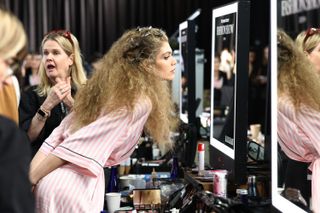 Valentina Sampaio wears a pink striped robe backstage at the Victoria's Secret Fashion Show