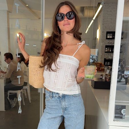 Woman in a white embroidered top and jeans