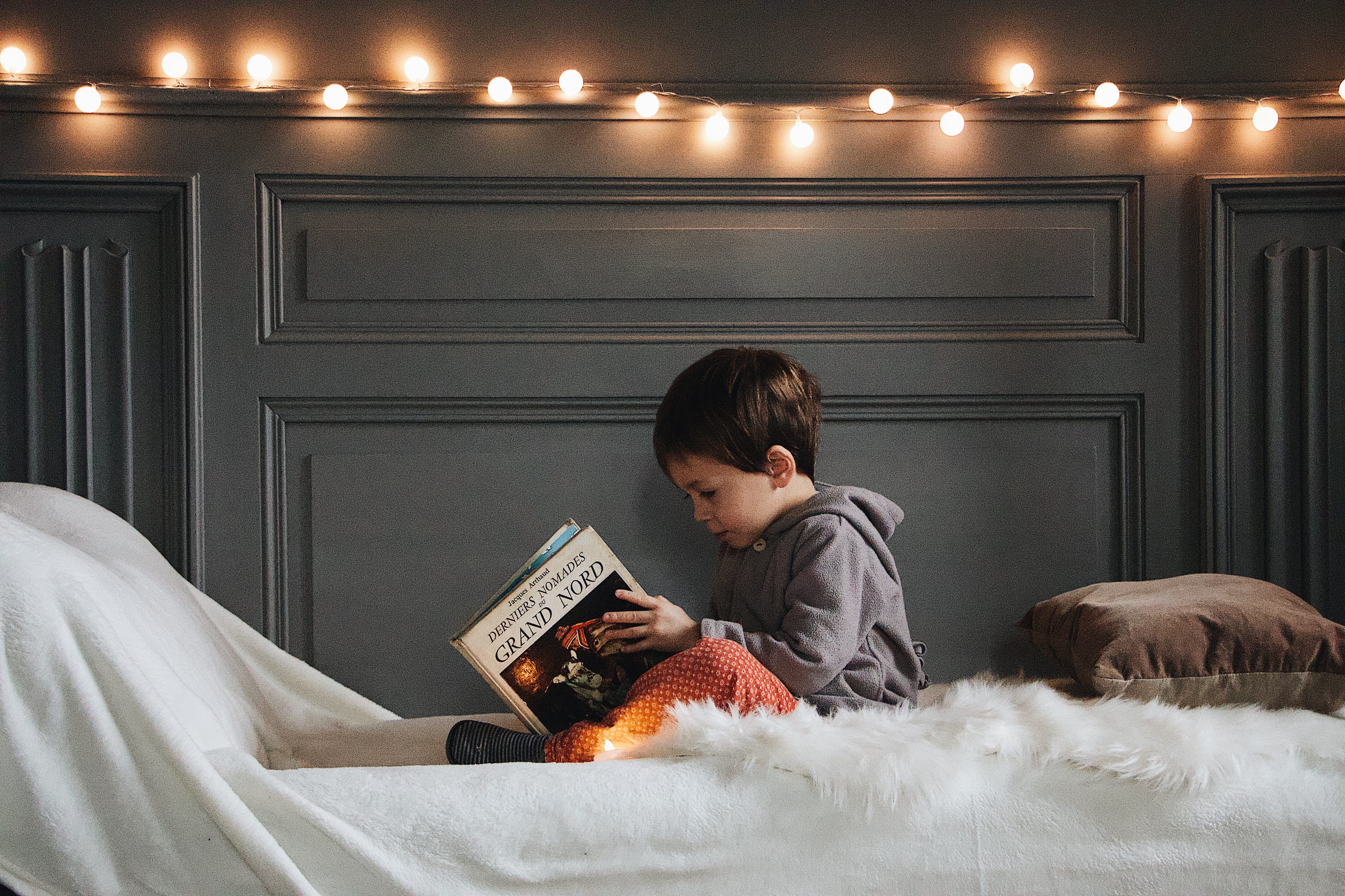 How to help your child sleep Christmas Eve a child is shown reading a book on his bed