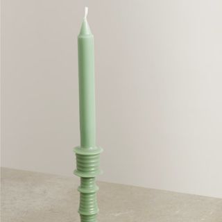 A soft green taper candle