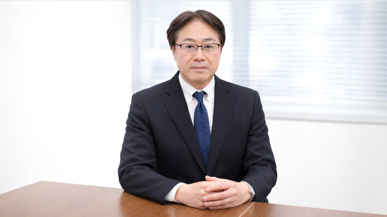 OM System CEO Shigemitsu Sugimoto sits at a desk