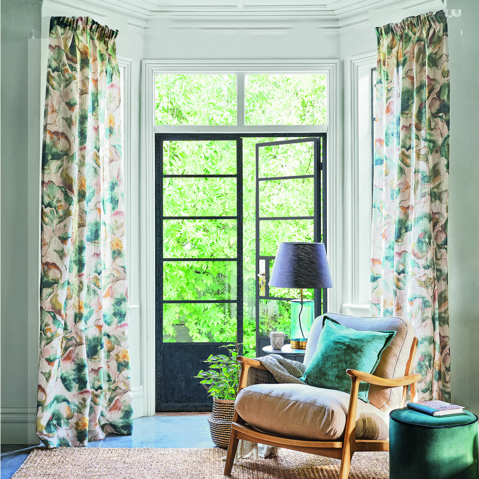 Living room with large french doors, full length curtains and an armchair.