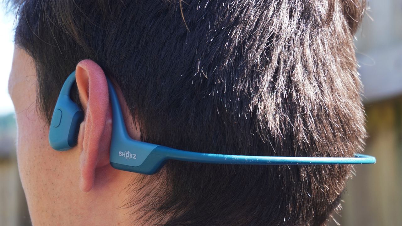 Male cyclist wearing the Shokz OpenRun Pro wireless headphones