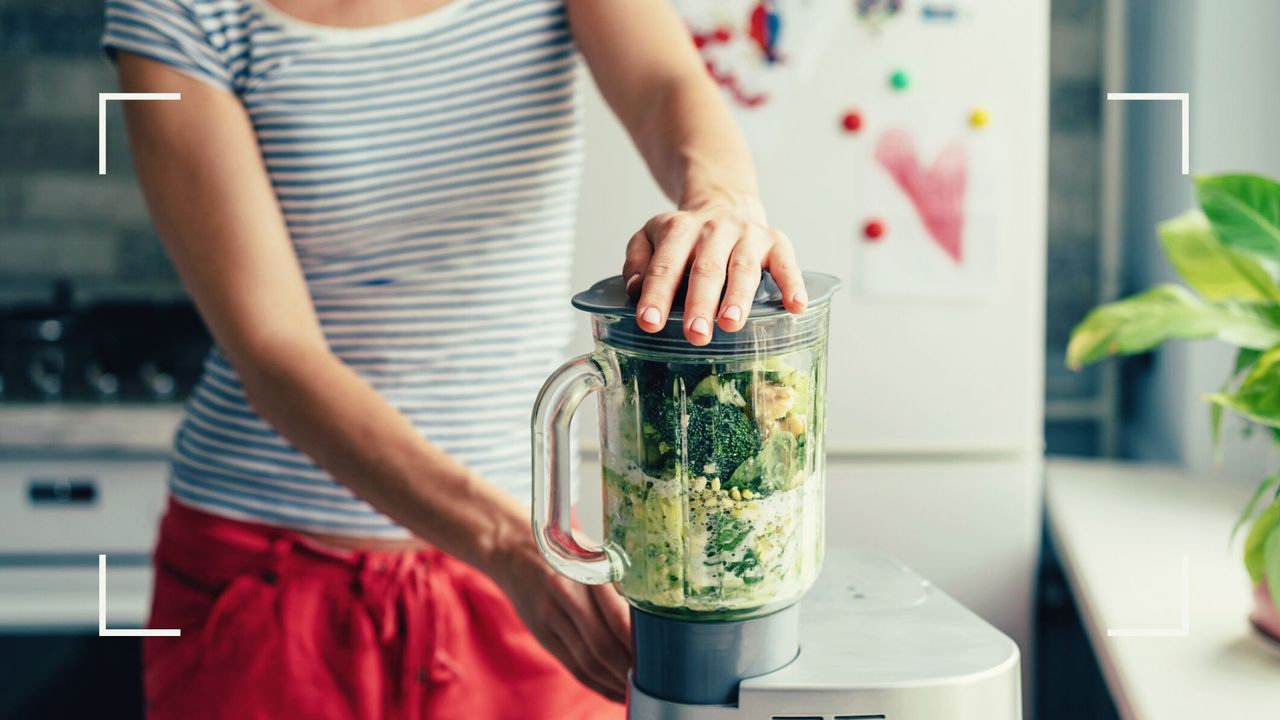 woman showing how to use a food processor in her kitchen