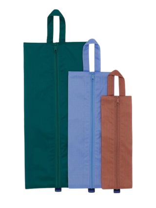 A set of three travel pouches, in petrol green, electric blue, and argilla, respectively.