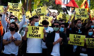 Valencia football club supporters hold placards reading "Lim, go home", during a protest against Singaporean business magnate and owner of the club Peter Lim, in Valencia, on December 11, 2021.