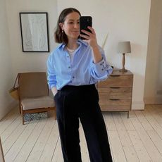 Woman wears blue shirt and black trousers