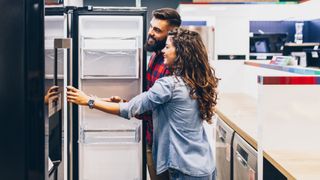 male and female couple shopping for a refrigerator