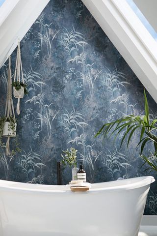 Rolltop bath with a dark blue botanical wallpaper background