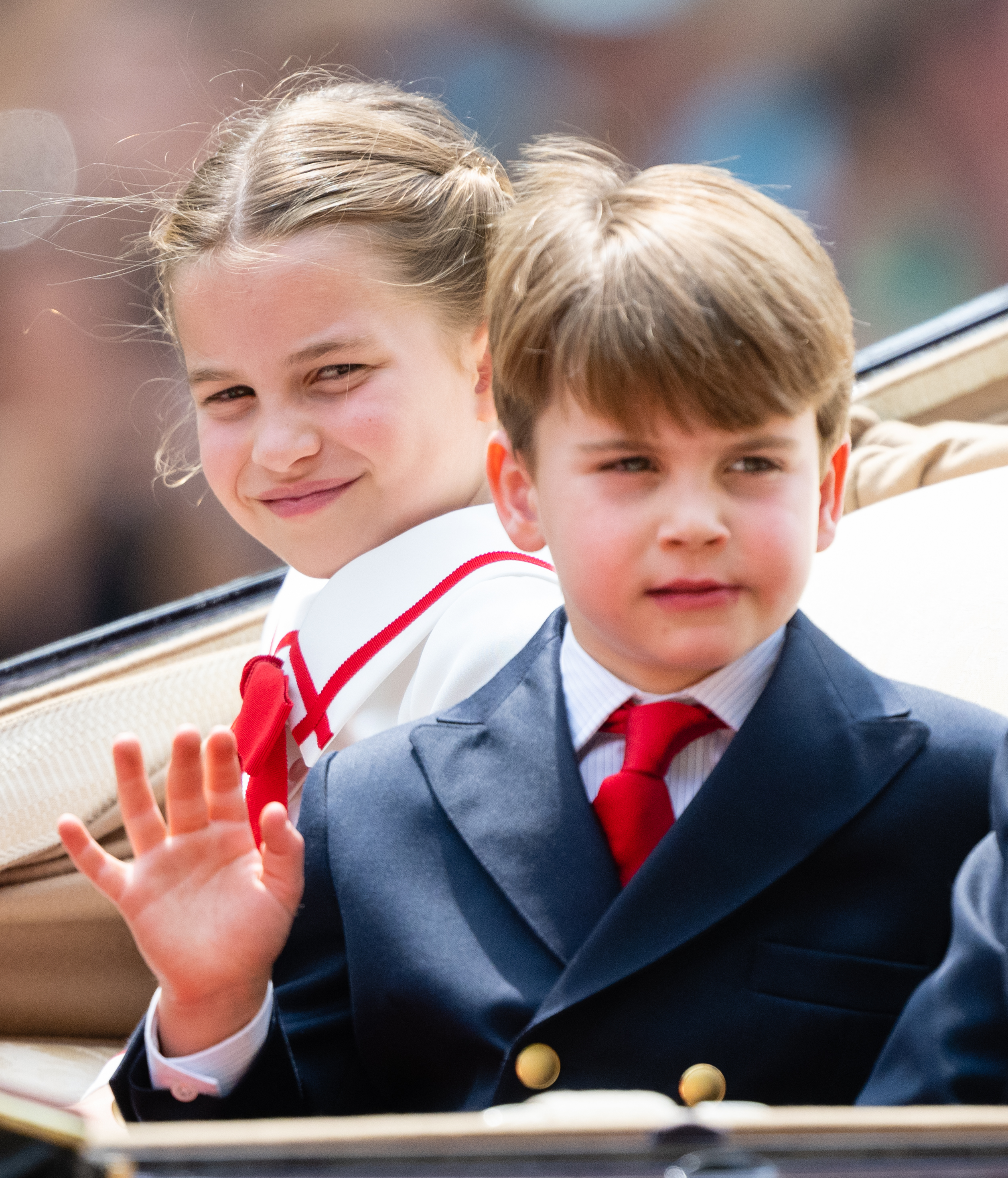 Princess Charlotte and Prince Louis riding in a carriage and waving