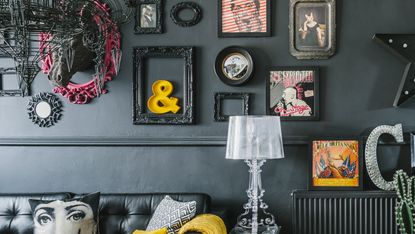dark living room with black walls and a quirky gallery wall