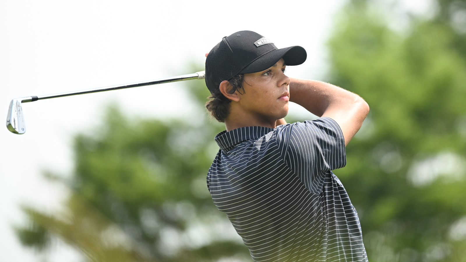 Charlie Woods hits an iron shot