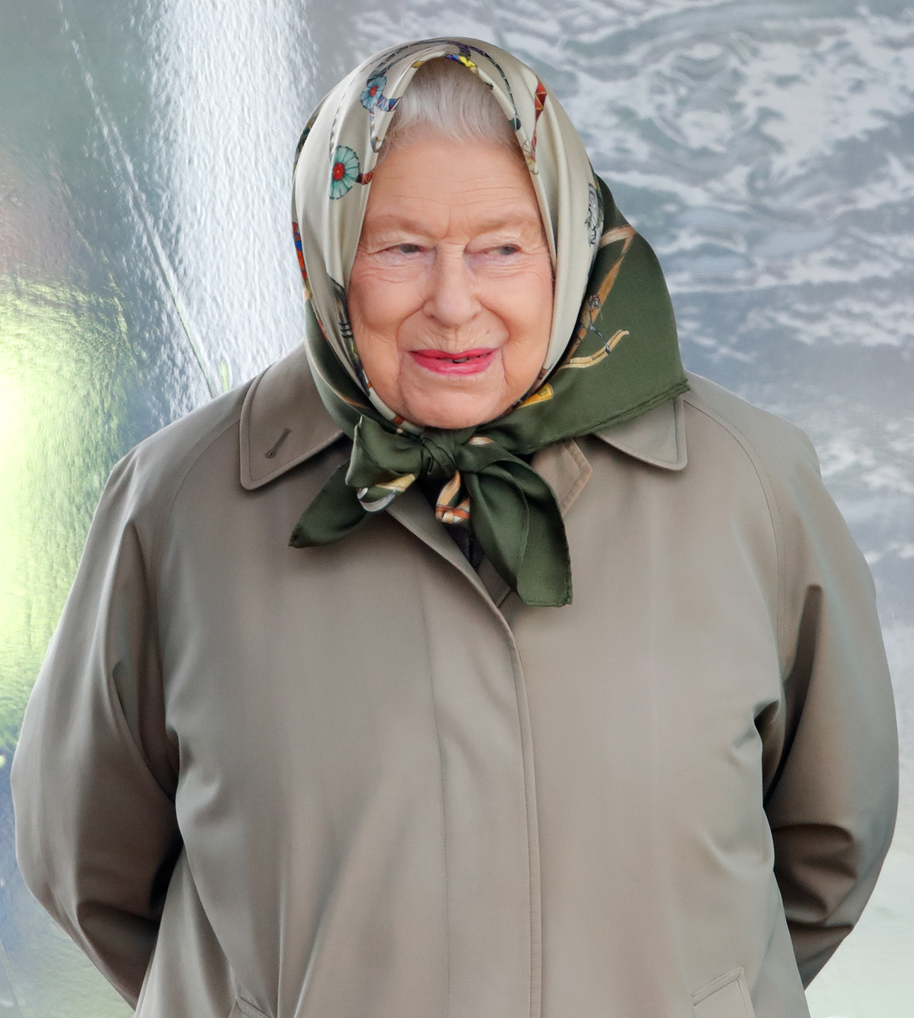Queen Elizabeth wearing a head scarf and smirking