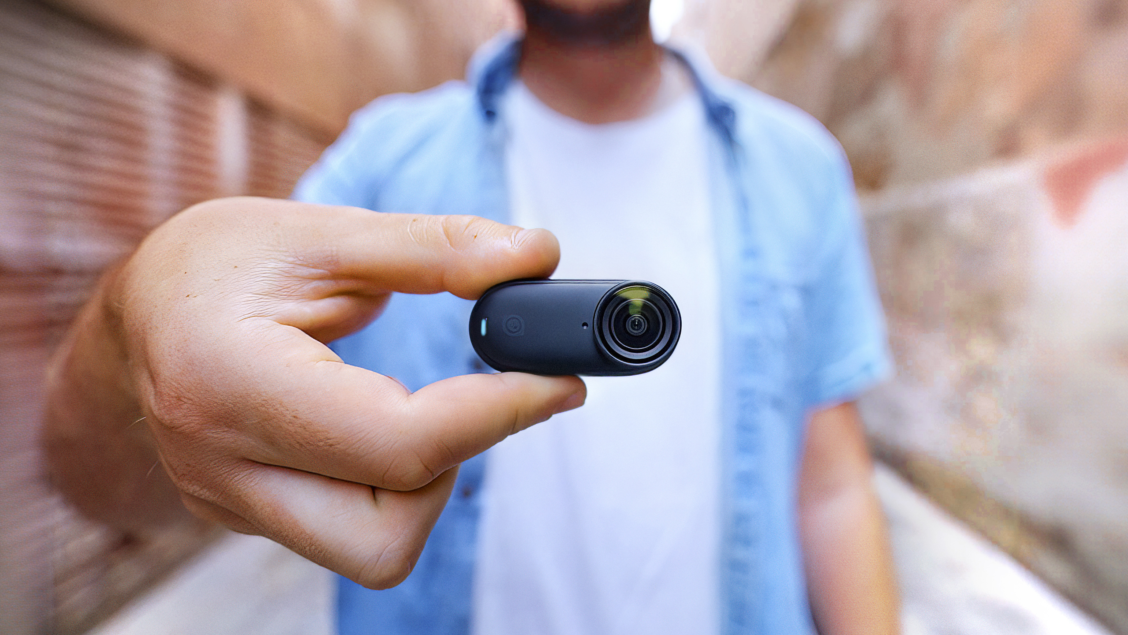 Insta360 Go 3S camera close up view with a person out of focus
