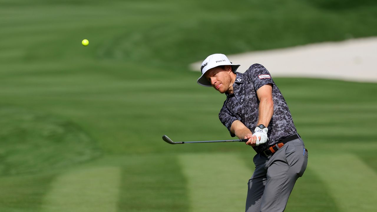 Peter Malnati practices with a yellow golf ball at the Players Championship 2024