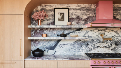 a kitchen with a bold marble backsplash