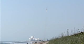 Beachgoers watch a United Launch Alliance Atlas 5 rocket and its classified NROL-33 payload launch into space from Florida's Cape Canaveral Air Force Station on a mission for the U.S. National Reconnaissance Office on May 22, 2014.
