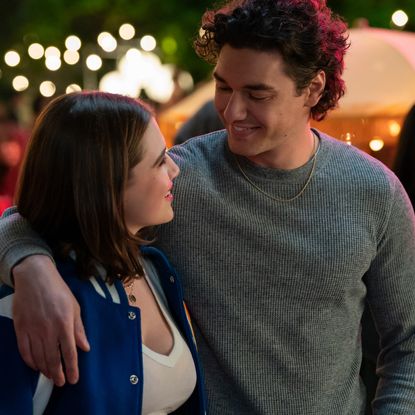 Hannah (Ella Bright) and Garrett (Belmont Cameli) walk with his arm over her shoulder through an on campus event in off campus season 1