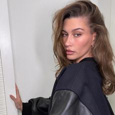 Hailey wears a black bomber jacket.