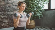 Woman doing arm workout with dumbbells at home