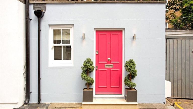 Skinny home with pink door and powder blue facade in London
