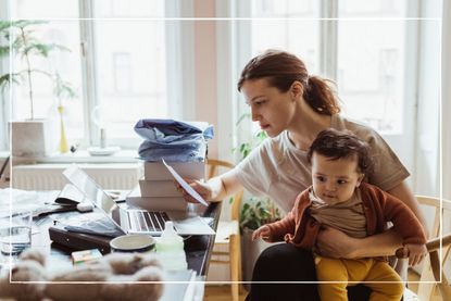 Businesswoman reading document while sitting with baby boy in living room